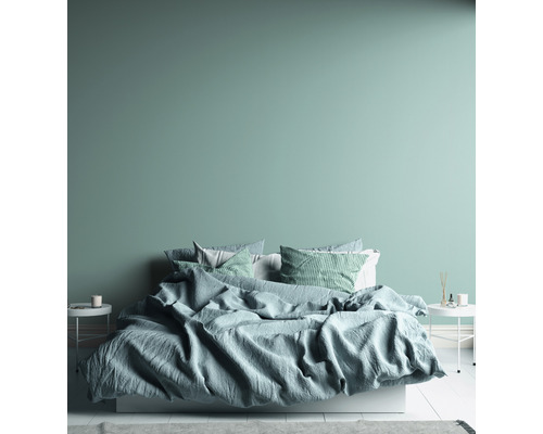 Spálňa s posteľou, vankúšmi a nočnými stolíkmi.