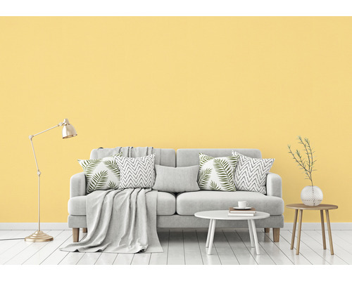 Svetlá obývacia izba s pohovkou, vankúšmi, stolom a stojacou lampou