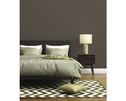 Spálňa s posteľou, nočnou lampou a kobercom so vzorom cikcak