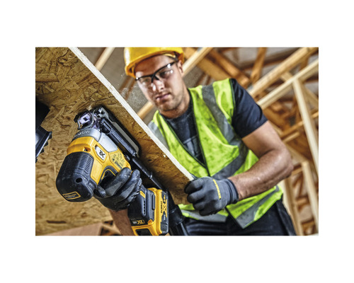 Remeselník upevňuje drevenú dosku pomocou akumulátorovej klincovačky DeWalt