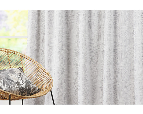 Dekoračná látka s palmovým vzorom vedľa prúteného kresla