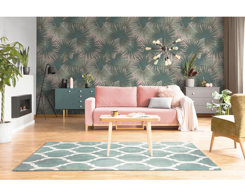 Obývacia izba s tapetou s motívom palmových listov, pohovkou, kobercom a nábytkom.