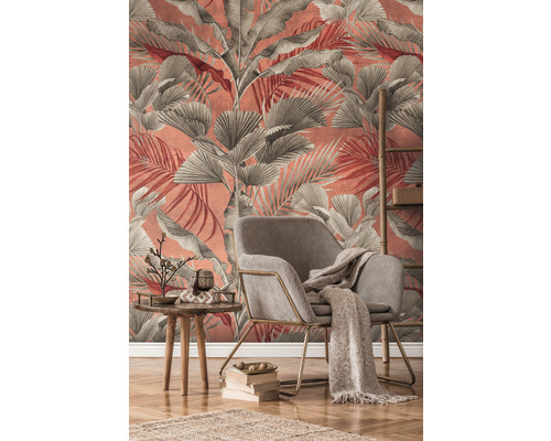 Obývacia izba s kreslom, stolom a dekoráciou pred stenou s tapetou s listami