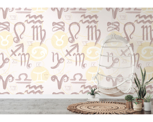 Izba s tapetou so vzorom znamení zverokruhu, závesné ratanové kreslo a izbové rastliny