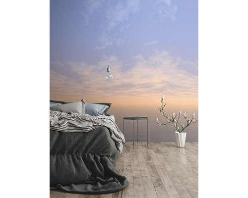 Spálňa s posteľou, príručným stolíkom, vázou na kvety a tapetou s motívom oblohy