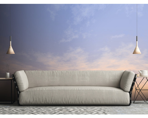 Obývacia izba s pohovkou, príručnými stolíkmi, závesnými svietidlami a vzorovaným kobercom