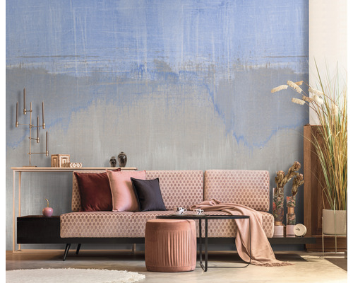 Obývacia izba so vzorovanou tapetou, pohovkou, stoličkou a dekoráciou