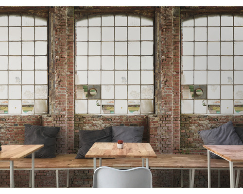 Interiér s tehlovou stenou a veľkými oknami a tiež stoly a posedenie.