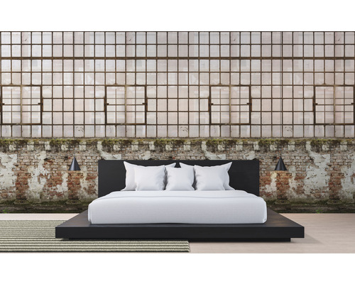 Spálňa s posteľou pred tehlovou stenou a veľkými oknami