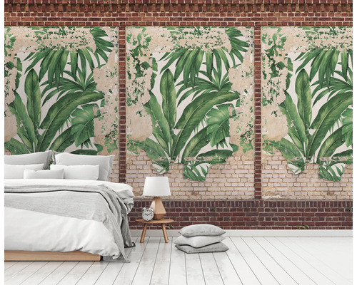 Nástenná dekorácia s motívom tropických listov v miestnosti s posteľou a tehlovou stenou