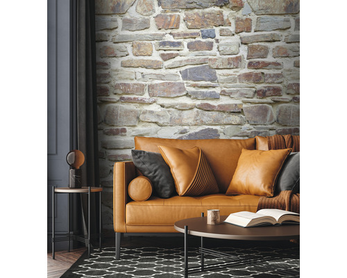 Obývacia izba s pohovkou, vankúšmi, stolom a tapetou s kamennou stenou