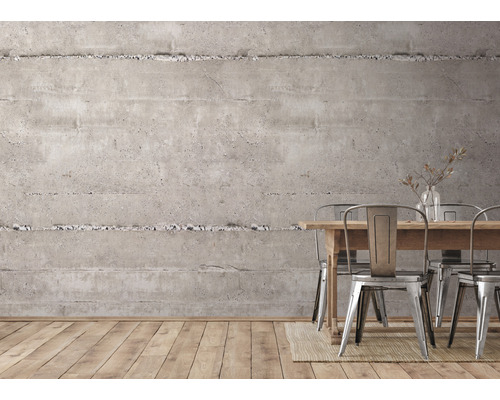 Interiér s betónovou stenou, dreveným stolom a kovovými stoličkami.