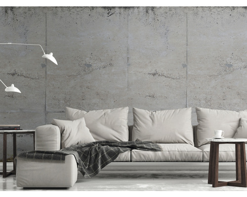 Obývacia izba s pohovkou, príručným stolíkom a stojacou lampou pred betónovou stenou