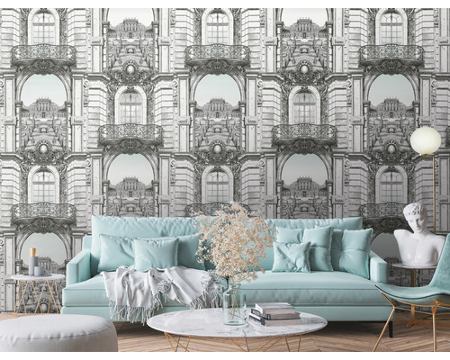 Obývacia izba so vzorovanou tapetou, pohovkou a dekoráciami