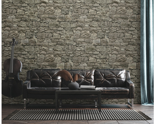 Obývacia izba s kamennou stenou, koženou pohovkou a violončelom