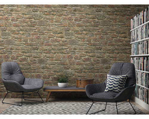 Obývacia izba s tapetou kamennej steny, dve kreslá, koberec a knižnica
