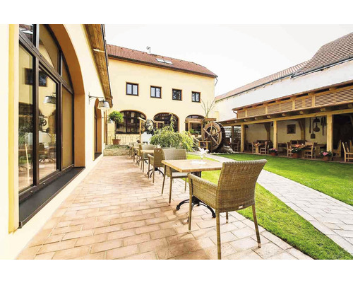 Vonkajší priestor so stolmi, stoličkami a vodným kolesom