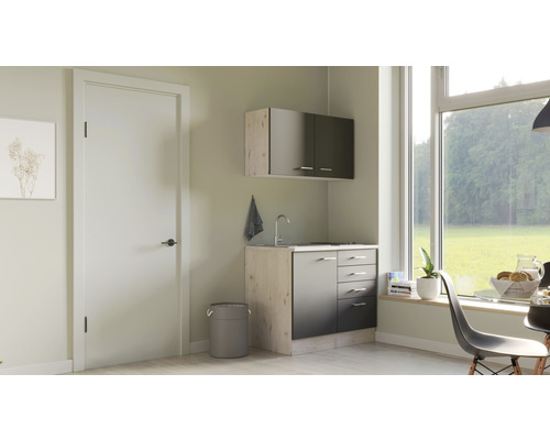 Malý kuchynský kút so závesnou skrinkou, umývadlom a odpadkovým košom vo svetlej miestnosti