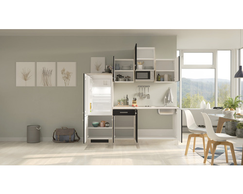 Kompaktná kuchynská linka s drezom, chladničkou, závesnými skrinkami a jedálenským stolom vo svetlej izbe