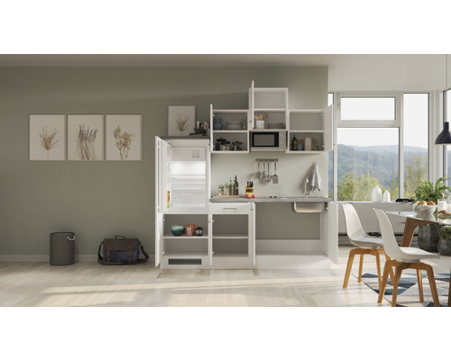 Kuchynská linka s chladničkou, drezom a závesnými skrinkami vo svetlej miestnosti