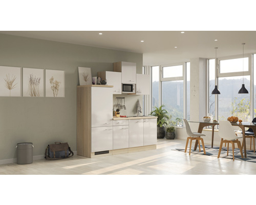 Kompaktná kuchynská linka v svetlej a modernej izbe s jedálenským kútom a veľkými oknami.