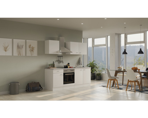 Svetlá kuchyňa so vstavanými skriňami, digestorom a jedálenským stolom v modernom obývacom priestore.