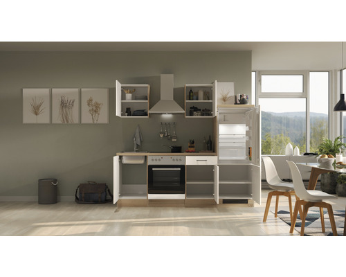 Kompletná kuchynská linka s drezom, sporákom, rúrou, digestorom, hornými skrinkami a chladničkou v svetlej, moderne zariadenej izbe.