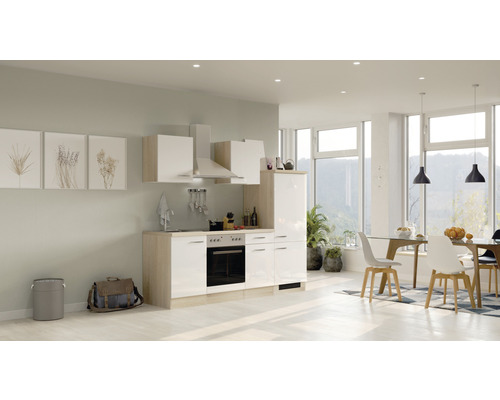 Svetlá vstavaná kuchyňa s elektrickými spotrebičmi a jedálenským kútom v moderne zariadenej izbe.