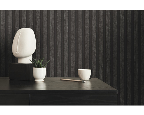 Dekoratívne zátišie na tmavom drevenom písacom stole pred štruktúrovanou nástennou tapetou.