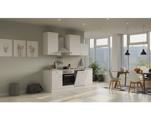 Moderná kuchyňa s bielymi skrinkami, odsávačom pár a jedálenským kútom v svetlej miestnosti.