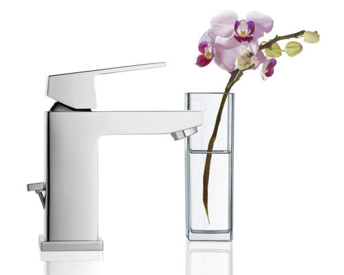 Chrómovaná umývadlová batéria vedľa vázy s orchideou