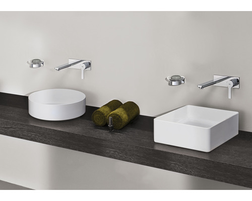 Kúpeľňa s okrúhlymi a obdĺžnikovými umývadlami na dosku, batériami a uterákmi na tmavej polici