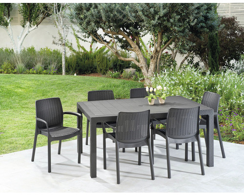 Záhradná scéna s čiernym záhradným stolom a šiestimi čiernymi stoličkami na terase so stromami v pozadí.