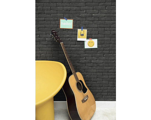 Dekoratívny kamenný múr s gitarou a žltou stoličkou pre štýlový interiér