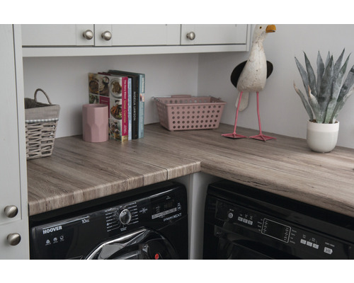 Práčovňa s drevenou pracovnou doskou, práčkou, košom na bielizeň a dekoráciami