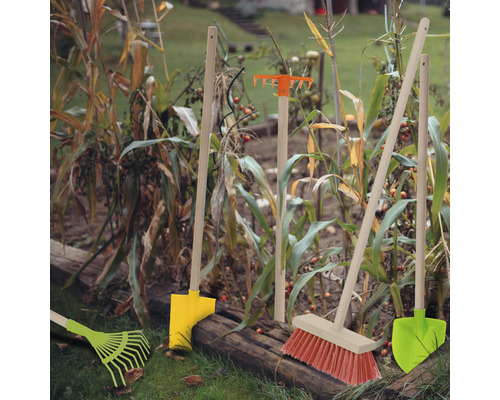 Záhradné náradie ako hrable, lopata a metla v záhradnom záhone
