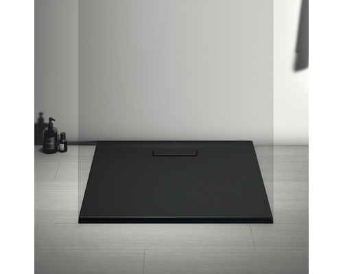 Čierna sprchová vanička s odtokovou súpravou v kúpeľni.