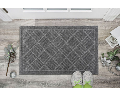 Sivá rohožka s geometrickým vzorom pred dverami