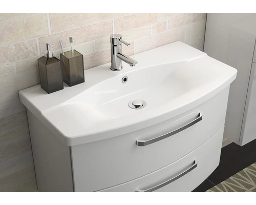 Biela skrinka pod umývadlo s umývadlom a dvoma zásuvkami, batéria, dávkovač mydla a pohár na zubné kefky.