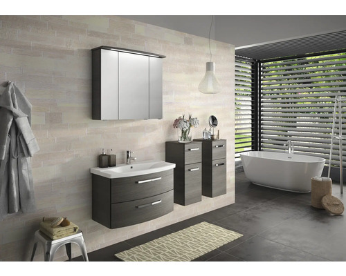 Moderná kúpeľňa s umývadlovou skrinkou, zrkadlovou skrinkou, bočnou skrinkou a vaňou pod oknom so žalúziami.