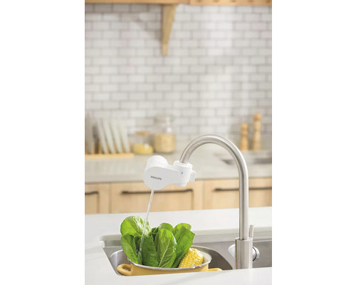 Kuchynská scéna s namontovaným kohútikovým filtrom značky Philips pri umývaní zeleniny