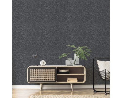 Detailný záber na textúrovanú tmavú tapetu v obývacej izbe, kombinovaný s drevenou skrinkou a kovovou stoličkou.