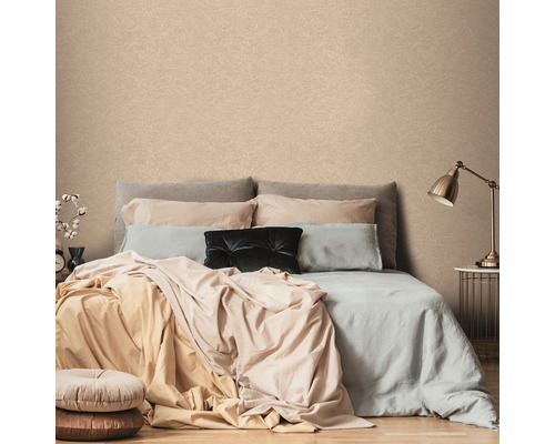 Spálňa so vzorovanou tapetou za posteľou.