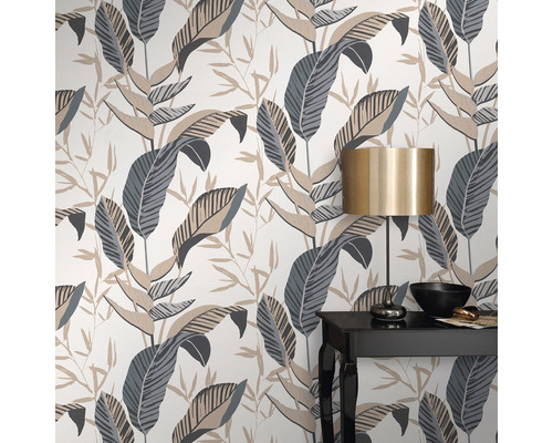 Tapeta s motívom listov a stôl s lampou