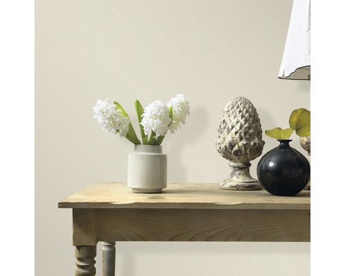 Dekoratívne prvky na drevenom stole pred stenou.