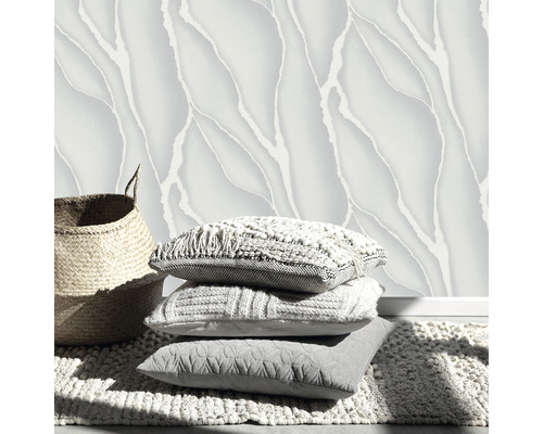 Dekoratívny dizajn stien s vzorovanými tapetami, hromadou vankúšov a košom na koberci