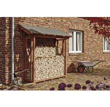 Drevený sklad dreva so strechou, plný polien, v záhrade vedľa tehlovej budovy