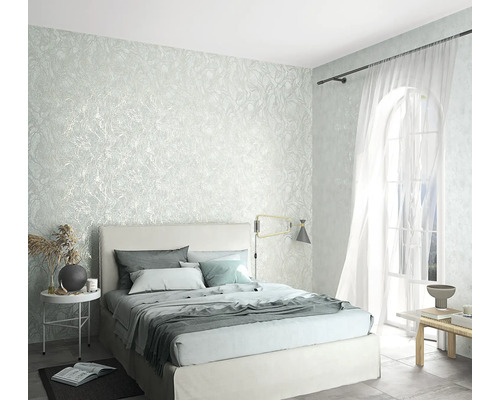 Spálňa s textúrovanými tapetami, posteľou a oknami pre svetlú atmosféru miestnosti