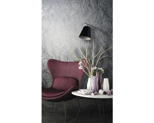 Obývacia izba s kreslom, stolom a tapetou s kvetinovým vzorom