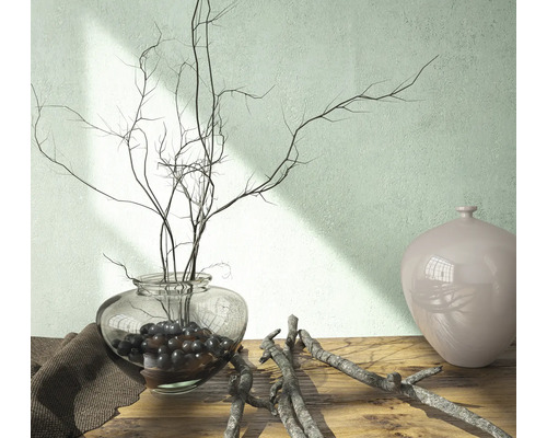 Dekoratívna scéna so sklenenou vázou, vetvami a keramickou vázou na drevenom stole